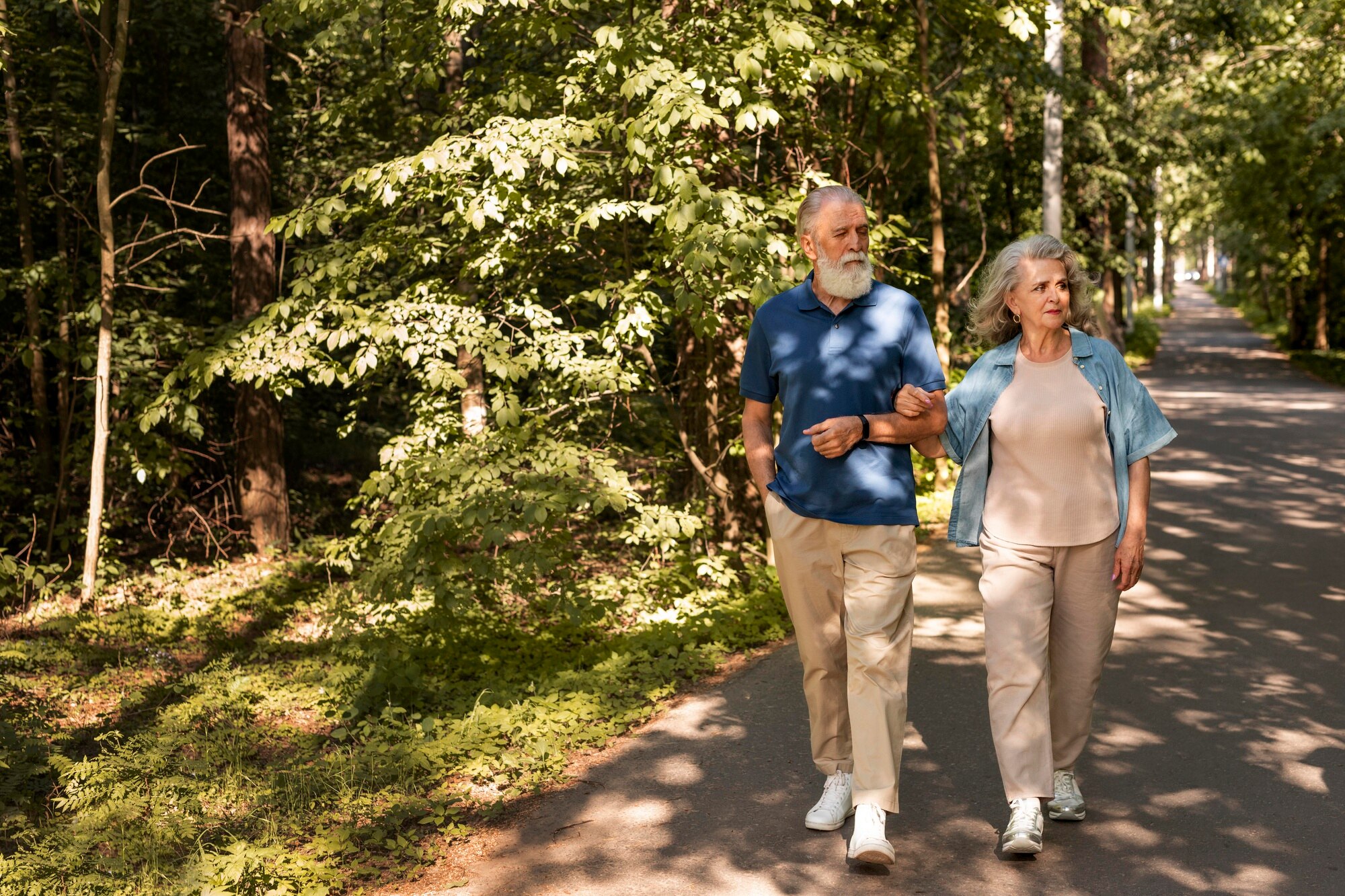 Adulto mayor caminando activamente en un parque, cuidando sus articulaciones